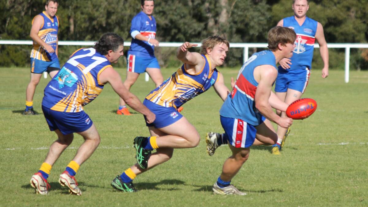 • Merimbula Digger Tom Burch handballs to a team-mate as two Breakers close in to tackle him on Saturday. The Diggers lost the game by just five points, but sit in second place on the ladder for the finals and will have a rematch with the Breakers this weekend. 