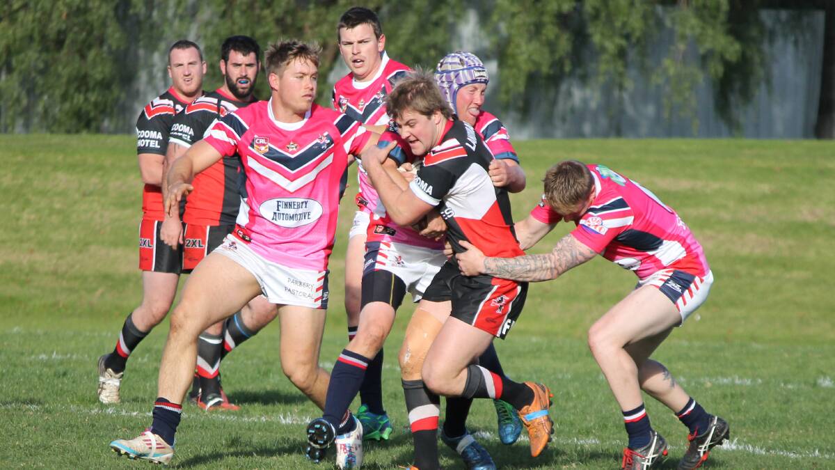 • Cooma’s Jackson Standen gets wrapped up by Ryan Apps (left) Craig Matthews and Blake Robinson during the Roosters charity day recently. The Roosters will face the Moruya Sharks this weekend in all four grades. 