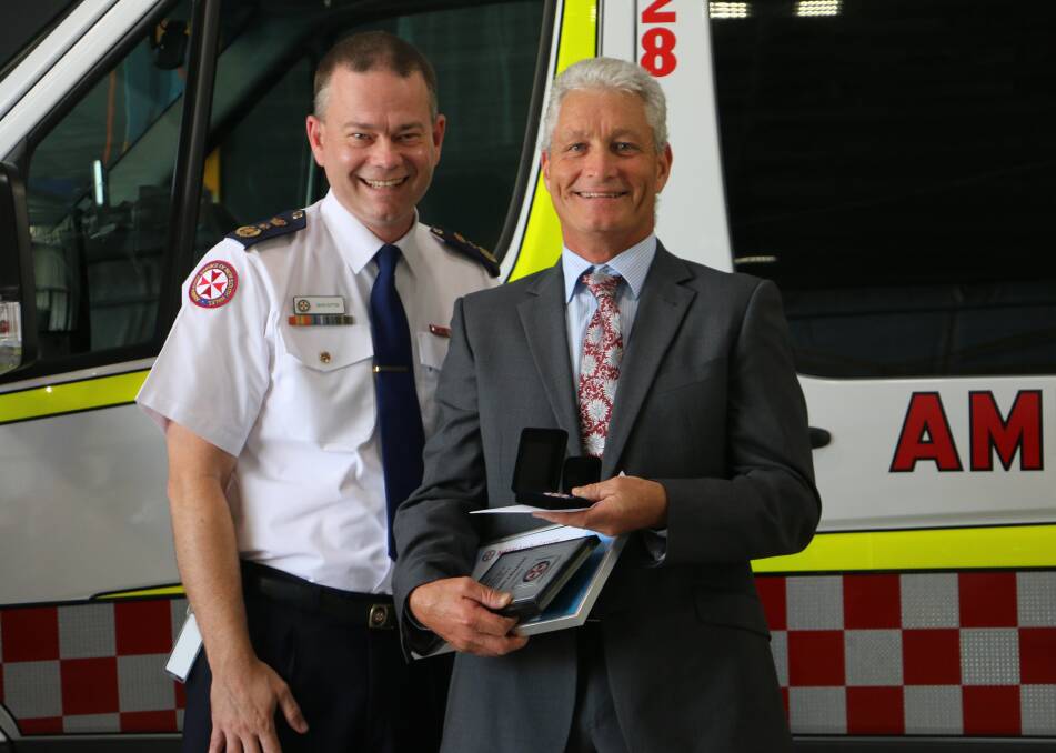 Real hero: Commissioner David Dutton presented Geoff Harling of Merimbula Ambulance Station with retirement gifts after 36 years of dedicated service. Photo: NSW Ambulance